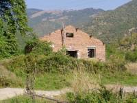Trosky opuštěných domů na okraji vesnice
